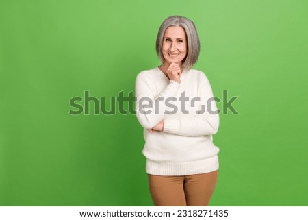 Photo of pensioner lady touch chin smart minded thoughtful decide about her business company income isolated on green color background