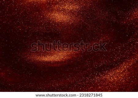 Beautiful flying shiny golden particles on a red background. Amazing golden particles in red fluid. Glittering flows of gold particles in red liquid. Royalty-Free Stock Photo #2318271845