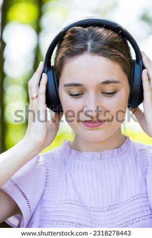 Woman with headphones, in close up and listening to music, freedom and happy with technology outdoor. Mockup space, podcast or radio streaming, female person in green setting and audio playlist. High