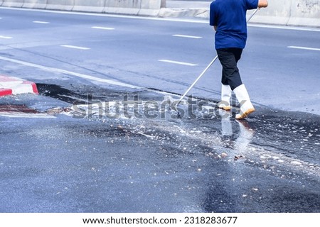 Selective focus to worker using wiper or squeegee to clean floor surface. Staff cleaning floor with wiper. The concept of cleaning service. Royalty-Free Stock Photo #2318283677