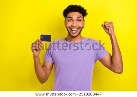 Photo of young man addicted spending his money wireless card fist up hooray free credit offer business isolated on yellow color background