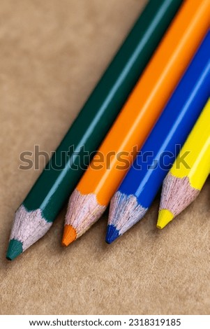 Wooden colourful pencils with sharpening shavings, on wooden table