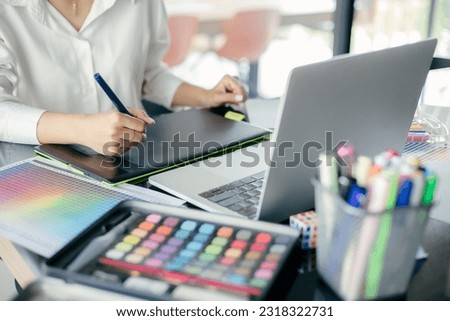 Graphic designer using graphics tablet to do his work at desk