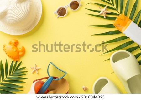 Tropical resort with kids. Top view photo of empty place surrounded by palm leaves and shells, sand toys, sunscreen bottle, slippers with panama on yellow isolated background with copyspace
