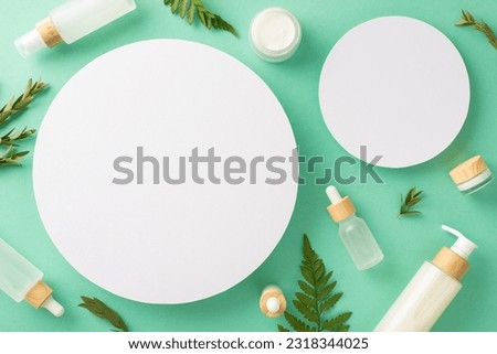 Healthy skincare cosmetics concept. Above view photo of two empty circle frames with cosmetic containers and bracken and eucalyptus branches on isolated teal background with copy-space