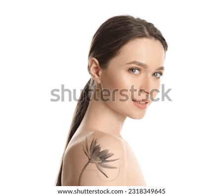Young woman with beautiful flower tattoo on white background, side view