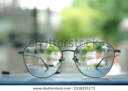 Eyeglasses on table, progressive lenses, eyeglasses for the elderly, glasses progressive lens, eyeglass progressive lens, close-up of glasses on lenses test, looking through glasses Royalty-Free Stock Photo #2318355171