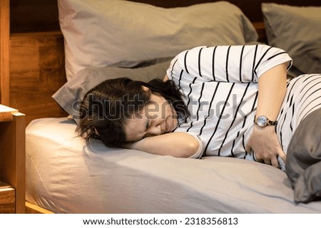 Middle aged woman touching right lower abdomen,acute abdominal pain with appendicitis,painful and inflammation of appendix,sick female patient with Ruptured Appendicitis,health care,medical concept Royalty-Free Stock Photo #2318356813