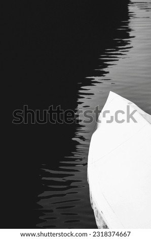 Black and white abstract minimalist picture with a boat on the water.