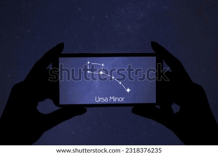 Woman using stargazing app on her phone at night, closeup. Identified stick figure pattern of Little Bear (Ursa Minor) constellation on device screen Royalty-Free Stock Photo #2318376235