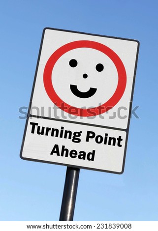 A Turning Point is ahead written on a road sign with a smiling face against a clear blue sky background