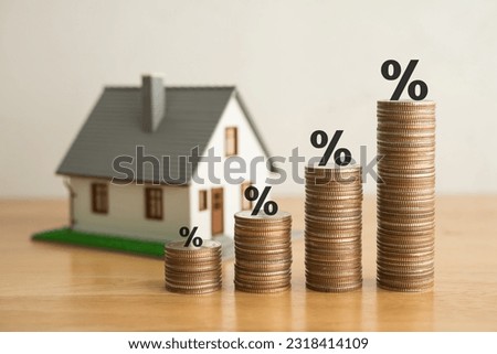 Stack coins as graph trend up and interest rates with house model background. FED fix recession inflation crisis by increase interest rate that effect to house buyer. Mortgage loan, financial concept. Royalty-Free Stock Photo #2318414109