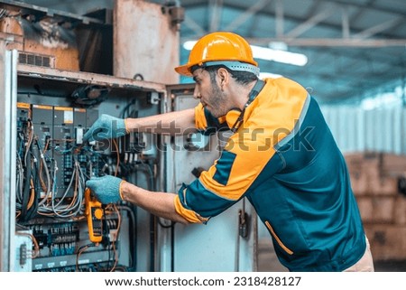 Electrical technician tests wiring, polarity, grounding, voltages and performs electrical maintenance using hand tools that involve clamp meter, screwdriver, and cutter. The foreman's routine tasks. Royalty-Free Stock Photo #2318428127
