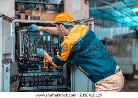 Electrical technician tests wiring, polarity, grounding, voltages and performs electrical maintenance using hand tools that involve clamp meter, screwdriver, and cutter. The foreman's routine tasks. Royalty-Free Stock Photo #2318428129
