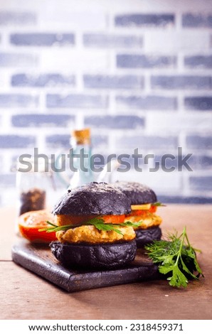 Tasty craft burger with black bun on the board