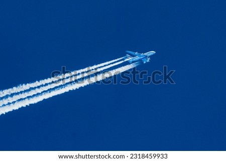Sharp telephoto close-up of jet plane aircraft with contrails cruising from Dubai to Los Angeles, altitude AGL 39,000 feet, ground speed 551 knots. Royalty-Free Stock Photo #2318459933