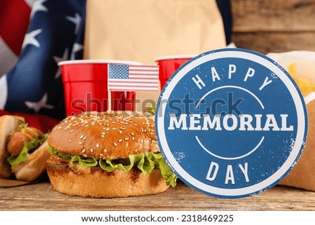 Card with text HAPPY MEMORIAL DAY, tasty burger, hot dog and cups of cola on wooden background, closeup