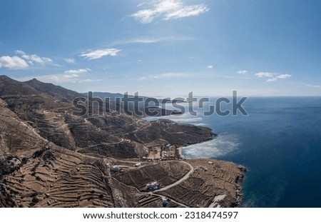 Tinos island, Cyclades Greece. Aerial panoramic drone view of rocky landscape and coast, rippled sea water, sunny day. 