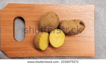 sliced ​​potatoes on a wooden cutting board on a gray background