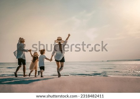 Happy Asian family consisting of father, mother, Son and daughter having fun playing on the beach during summer vacation on the beach. Happy family and vacation concept. Royalty-Free Stock Photo #2318482411