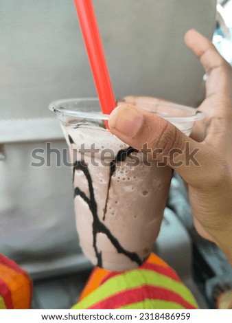 chocolate milk shake with syrup in hand