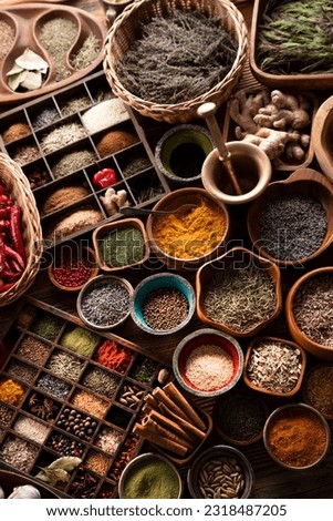 Spices background. Colorful dry and fresh spices in teak and ceramic bowls, on rustic wooden table.