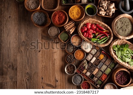 Spices background. Colorful dry and fresh spices in teak and ceramic bowls, on rustic wooden table.