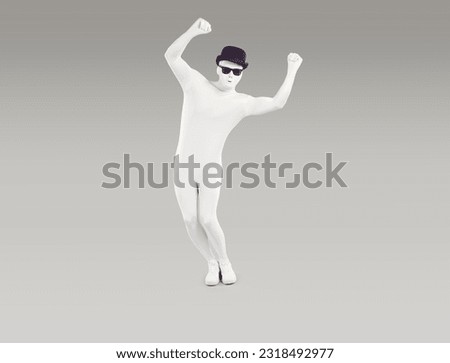 Unknown person dressed in white leotard dancing with his hands raised. Full length portrait of faceless man wearing full body white suit, black hat and sunglasses posing on isolated studio background Royalty-Free Stock Photo #2318492977