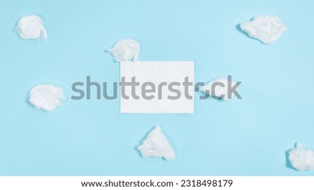 White paper closed envelope flies through white clouds on a blue background. Concept of delivering mail, letters and messages. Flat lay. Copy space.