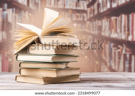 Book with opened pages and stacked books on reading desk in library. National library, books lovers day or month. Back to school or education learning background. Copy space Royalty-Free Stock Photo #2318499077