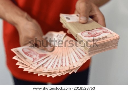 Hands holding pile of money. Serbian dinar paper currency, 1000 dinars value Royalty-Free Stock Photo #2318528763