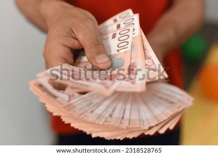 Hands holding pile of money. Serbian dinar paper currency, 1000 dinars value Royalty-Free Stock Photo #2318528765