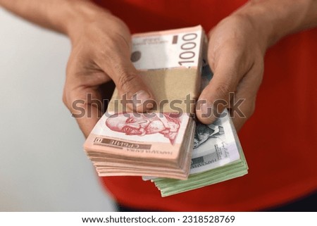 Hands holding pile of money. Serbian dinar paper currency, 1000 and 5000 dinars value Royalty-Free Stock Photo #2318528769