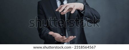 Business man with empty hand presenting something on grey background
