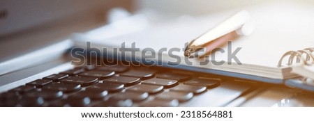 pen and notepad on the computer keyboard
