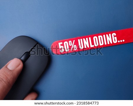 Wireless mouse and colored stick with the word fifty percent unloading on a blue background
