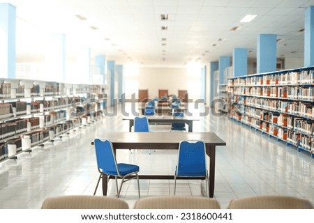 Public library interior with bookshelves. Workplace table and chairs for studying, college, university, high school students self preparation.  Royalty-Free Stock Photo #2318600441