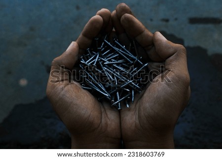 a bunch of iron nails in a man's hand