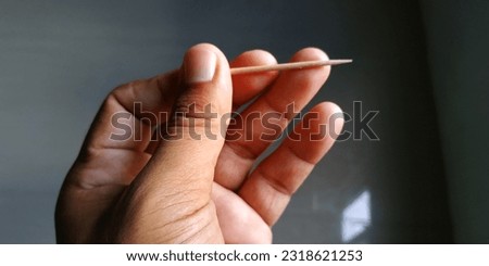 wooden toothpick in boy's hand Royalty-Free Stock Photo #2318621253