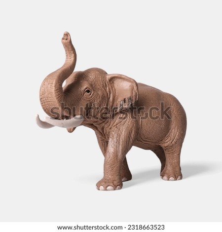 Close-up of a miniature toy elephant animal side view against a white background