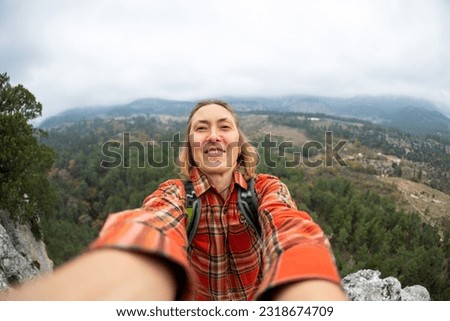 selfie of a woman on the background of a rocky and mountainous area. The girl smiles at the camera. Tourism, vacation concept