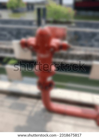 unfocused background red hydrant equipment. metal emergency tool sign and symbol.