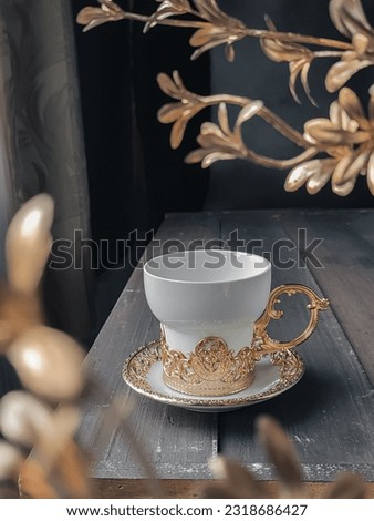 a beautiful white and gold cup on wooden table. Turkish ceramic. Selected focus, Still Life photography.