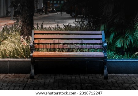 Wooden chairs on the sidewalk in dark tones, with two streams of hot and cold light on either side. Hot and cold contrasting background concept. nobody.