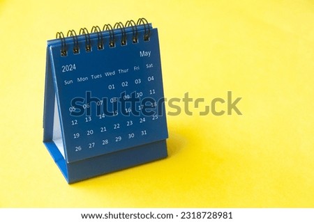 May 2023 blue desk calendar on yellow cover background with customizable space for text. Copy space and calendar concept
