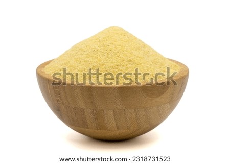 Dry organic semolina flour isolated on white background. Uncooked organic semolina in wooden bowl Royalty-Free Stock Photo #2318731523