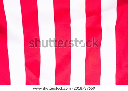 horizontally-oriented flag background with red and white stripes filling the majority of the frame
