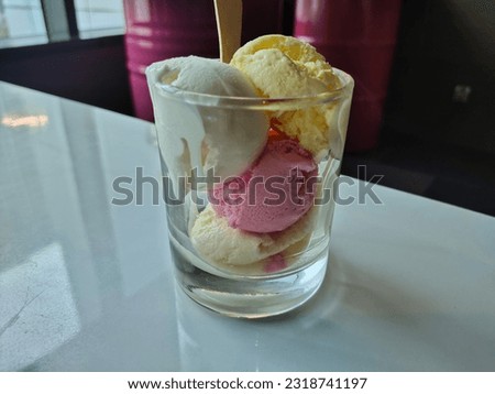 four scoops of ice cream, in the glass on the white table