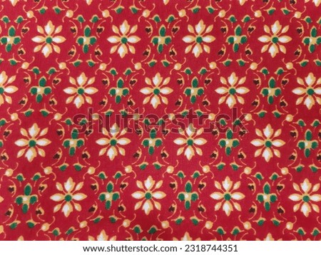 red thai fabric with white flowers and green leaves