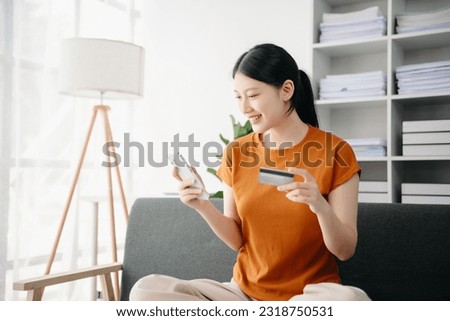 Asian young woman hands using smartphone and holding credit card sitting. Online Shopping payments concept.
